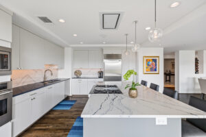 Spacious Dallas high-Rise Condo kitchen with white modern cabinetry by StyleCraft Cabinets TX